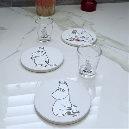 Set of coasters and glasses with Moomin character design on a marble surface